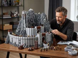 Imagem foca em um homem montando um set de Lego Senhor dos Anéis
