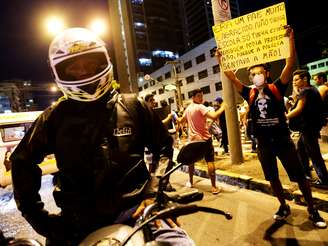 <p>Manifestante segura cartaz durante um protesto em Fortaleza pedindo mudanças sociais</p>