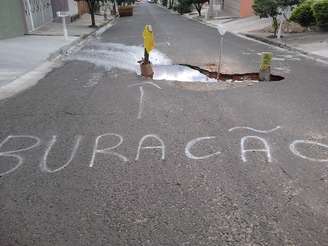 <p>Sinalização em buraco em rua do bairro Toffoli foi feita pelos próprios moradores, para evitar acidentes</p>
