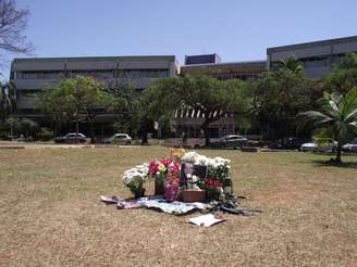 Vasos de flores, fotos, velas e uma flâmula do time do Palmeiras estão no gramado na Praça do Ciclo Baísico 2, onde o estudante Denis Casagrande recebeu os primeiros socorros