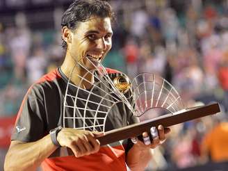 Rafael Nadal morde troféu do Rio Open após vitória sobre Dolgopolov
