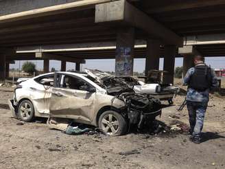 <p>Membro da força de segurança iraquiana inspeciona o local do ataque com carro-bomba em Ramadi neste 16 de abril</p>