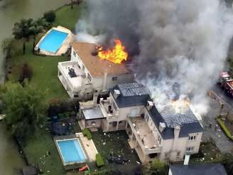 Casas em chamas após um pequeno avião ter caído na cidade de Tigre, na periferia norte de Buenos Aires, na Argentina