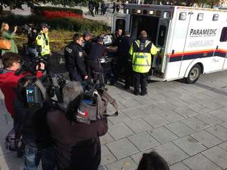 Soldado ferido a tiros perto do Parlamento do Canadá é movido para dentro de uma ambulância por policiais e médicos