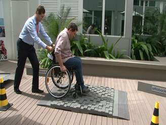 Cadeirantes sofrem para passar por uma calçada de pedra portuguesa