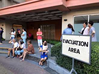 Moradores aguardam do lado de fora de prédio evacuado devido ao terremoto