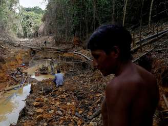 Yanomami segue agentes ambientais em uma mina de ouro durante operação contra o garimpo ilegal, em 2016