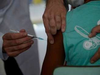 Imagem mostra um jovem negro sendo medicado por um enfermeiro no hospital.