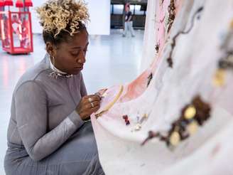 Na foto, a artista Micaela Cyrino está trabalhando em uma das obras expostas na mostra "Ah, Eu Amo As Mulheres Brasileiras!"