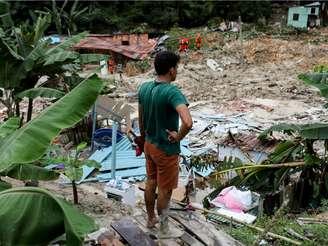 Morador do bairro Jorge Teixeira observa a destruição causada por um deslizamento de terra, em Manaus, em 13 de março de 2023.