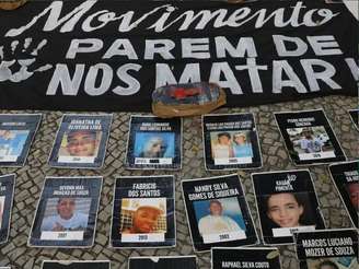 Imagem mostra algumas fotos de vítimas da polícia militar de Pernambuco estendidas no chão.
