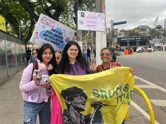 Priscila Alcântara, de 49 anos, e as filhas, a Vitória Bias, de 24 anos, e Monise Bias, de 16 anos, vendendo fotos polaroid na fila para o show do Bruno Mars no Estádio do MorumBIS, em São Paulo, em 4 de outubro de 2024.