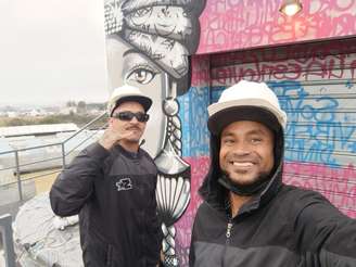 Os artistas Tiago Mordix e Dinas Miguel preparando os primeiros grafites do Palco Quebrada no The Town.	