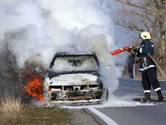 Bombeiro apaga incêndio em carro.
