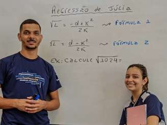 Julia e seu professor à frente de um quadro branco.