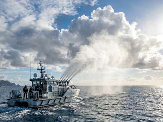 Imagem gerada por Inteligência Artificial mostra um navio lançando partículas de sal em direção à atmosfera para aumentar a refletividade das nuvens.