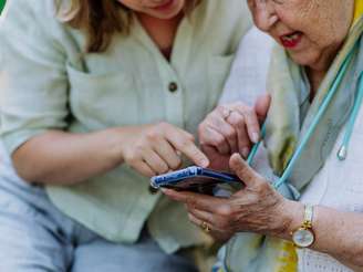 Idosa Sendo Ajudada Por Menina Mais Jovem A Mexer No Celular