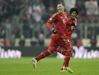 Schweinsteiger festeja com o brasileiro Dante, titular na vitória do Bayern