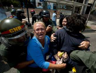 <p>Mulheres são detidas por agentes da Guarda Nacional Bolivariana em manifestação realizada em 14 de maio em Caracas</p>