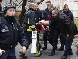 Bombeiros e policiais trabalham no resgate das vítimas do ataque terrorista contra a revista satírica "Charlie Hebdo"