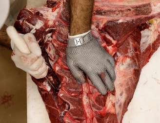 Funcionário corta pedaço de carne em um açougue em São Paulo. 26/06/2017 REUTERS/Paulo Whitaker