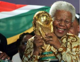 O ex-presidente Nelson Mandela segura troféu da Copa do Mundo depois que a África do Sul foi escolhida para sediar o Mundial de 2010, em Zurique, na Suíça, em maio de 2004. 15/05/2004