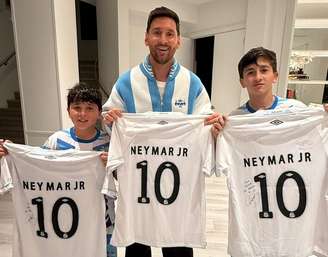 Lionel Messi e seus filhos com a camisa do Santos autografada por Neymar