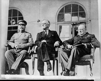 Roosevelt, Stalin e Churchill sentados juntos.