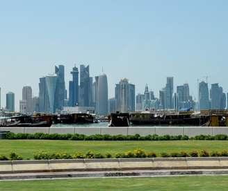 Localizada às margens do Golfo Pérsico, Doha é a capital moderna e vibrante do Catar, conhecida por sua arquitetura futurista, grandes avenidas e arranha-céus que se refletem nas águas do mar. A cidade cresceu rapidamente nas últimas décadas impulsionada pela riqueza do gás natural e do petróleo. Hoje reúne museus, centros culturais e uma orla sofisticada que simboliza a modernização do país.