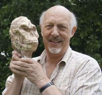 Ron Clarke, professor do Instituto de Estudos Evolutivos da Universidade Wits, na África do Sul, segura crânio do Pé Pequeno 