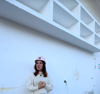 Maíra Cardi debaixo de armário suspenso em sua nova cozinha