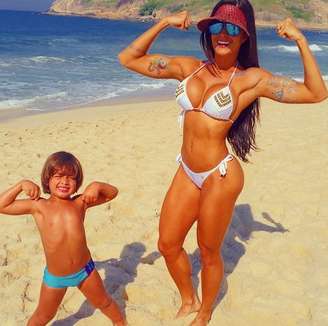 <p>A bailarina do Faustão Aline Riscado aproveitou a manhã de sábado (5) com seu filho na praia. Ela mostrou os músculos com um biquíni fio dental da Feriado Nacional, branco com desenhos dourados na parte de cima</p>