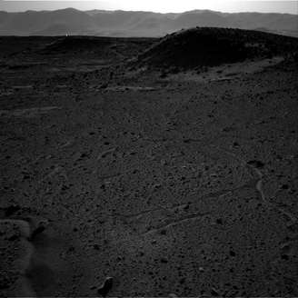 <p>Ponto luminoso aparece no fundo da foto, próximo às "montanhas", no horizonte de Marte</p>