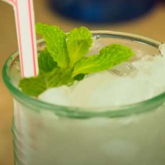Mojito é uma bebida que é preparada com rum branco, açúcar, suco de limão, água com gás, um ramo de hortelã e gelo picado.