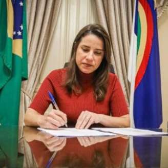 Governadora Raquel Lyra assinando documentos.