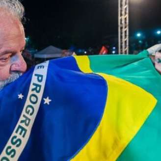 Presidente Lula beijando a bandeira do Brasil.