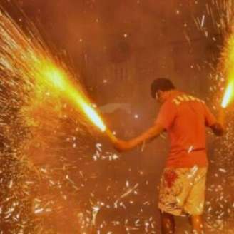 Homem brincando com fogos nos festejos juninos.