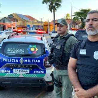 Policial Civil e Militar juntos ao lado de viatura da PMPE.