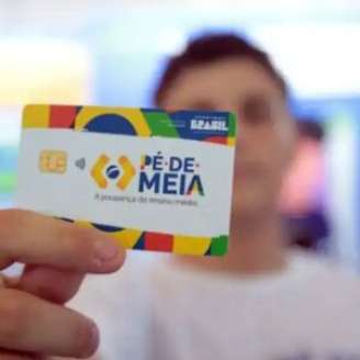 Pessoa segurando cartão do Pé-de-Meia.