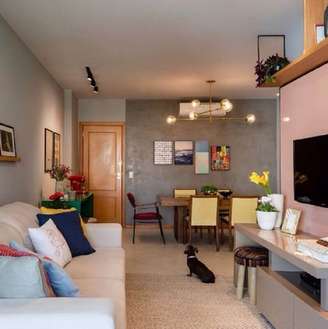 1. Decoração de sala de apartamento com almofadas coloridas e parede de cimento queimado – Foto: Muito Chique