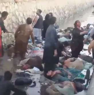 Feridos ao lado de cadáveres após ataque do lado de fora do aeroporto de Cabul, no Afeganistão 26/08/2021 AAMAJ NEWS AGENCY/via REUTERS