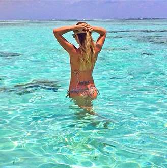<p>Carol Magalhães exibiu a boa forma com um biquíni colorido nas cristalinas águas das Maldivas. Com amarações, o modelito deixa à mostra a tatuagem da modelo e atriz acima do bumbum. O lacinho do top deixado de lado valoriza o desenho</p>