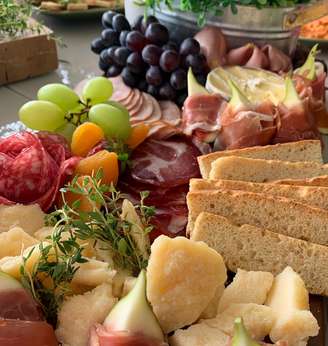 tabua de frios com frutas e pães