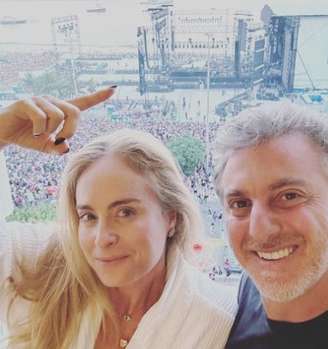 Angélica e Luciano mostram vista da janela do quarto em que estão hospedados