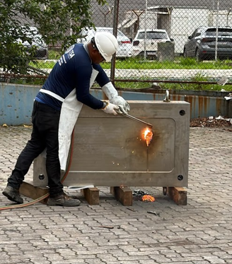 Funcionário abre com maçarico um molde de compressão industrial que escondia drogas; equipamento foi localizado no Aeroporto de Viracopos, em Campinas (SP)