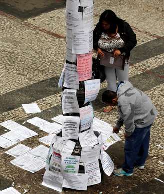 <p>Pessoas olham vagas de emprego no centro de São Paulo</p>