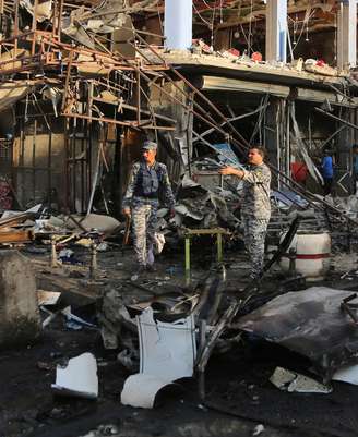 <p>Policiais iraquianos inspecionam o local de um ataque com carro-bomba perto de um restaurante no distrito de Nova Bagdá, Iraque, em 13 de agosto</p>