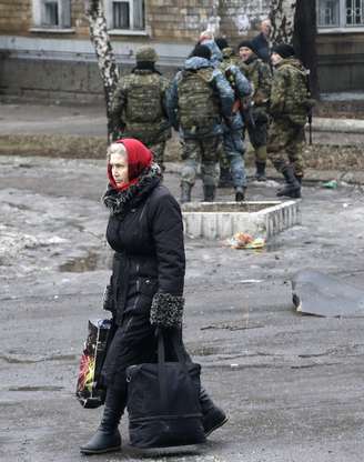 Uma mulher carrega seus pertences a um edifício usado como um centro de evacuação na cidade de Debaltseve, na Ucrânia, em 3 de fevereiro