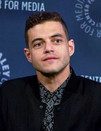 Rami Malek completou 45 anos no dia 12 de maio de 2026 e tem motivos de sobra para comemorar. Seu novo filme, “The Man I Love”, do diretor Ira Sachs, estará no Festival de Cannes, um dos maiores festivais de cinema do mundo, e concorrerá à Palma de Ouro. Estrelado por Malek, Tom Sturridge, Rebecca Hall e Ebon Moss-Bachrach, o longa é ambientado na Nova York dos anos 1980 e acompanha um ator de teatro que vive com AIDS e encara seu possível último grande papel.