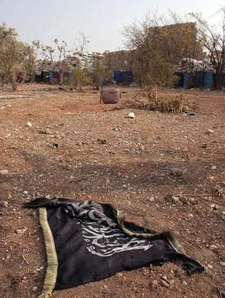 Bandeira do Estado Islâmico vista no chão perto de estrada na Síria, em foto de arquivo